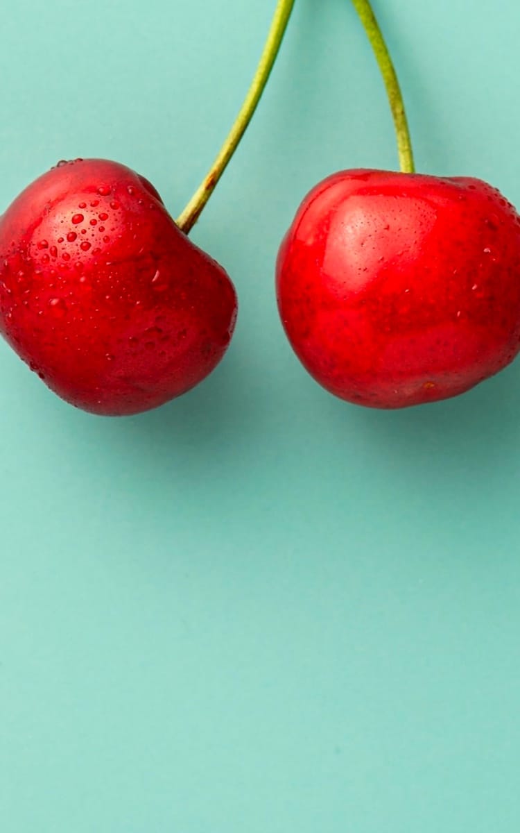 CHERRIES ON GREEN BACKGROUND